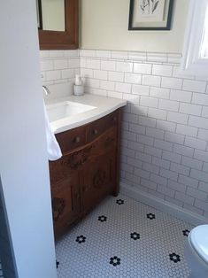 a bathroom with a sink, mirror and toilet in it's center area is shown