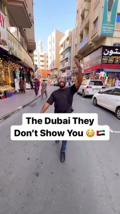 a man is walking down the street with his arms in the air and text that reads, the dubai they don't show you