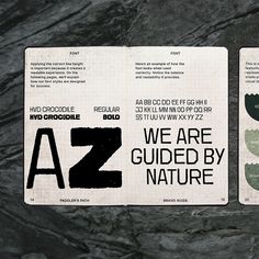 two booklets with black and white designs on them sitting on a stone surface next to each other