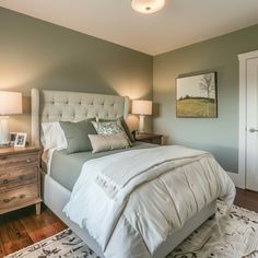 a bedroom with a bed, nightstands and two lamps on either side of the bed