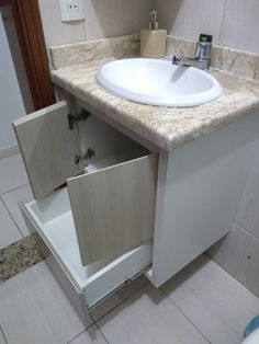 a white sink sitting inside of a bathroom next to a counter top with a mirror above it