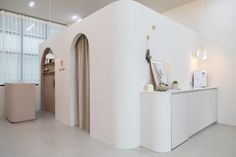 a white room with an arch shaped door and some pictures on the wall next to it