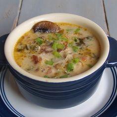 a blue and white plate topped with a bowl of soup