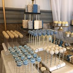 an assortment of cupcakes and cake pops displayed on a table