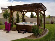 a hot tub in the middle of a yard with lights strung up on it's sides