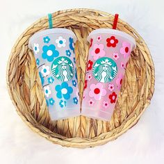 two starbucks cups sitting on top of a wicker basket next to eachother