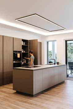 a woman standing at the counter in a kitchen