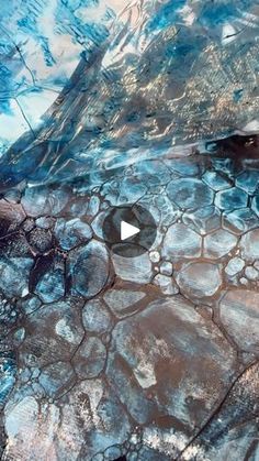 an aerial view of rocks and water with the sky reflected in it's surface