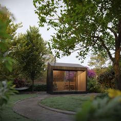 a small building sitting in the middle of a lush green park