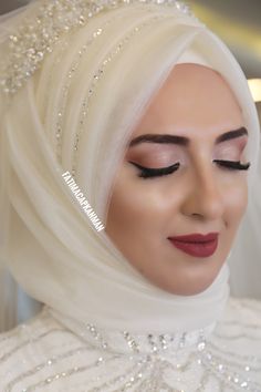 a woman wearing a white hijab with pearls on it's head and eyes