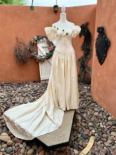 a dress is on display in front of a wall and some other things are around it