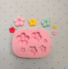 a pink cookie mold with flowers and butterflies around it on a polka dot tablecloth