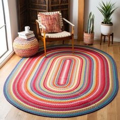 a room with a chair, rug and potted plant