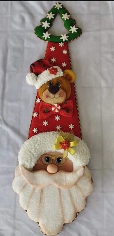 a christmas ornament with a teddy bear wearing a santa hat