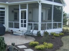 a house with a patio and chairs in the front yard, next to a fire pit