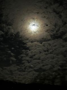 the moon is shining brightly in the cloudy sky