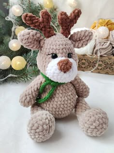 a crocheted stuffed animal sitting next to a christmas tree