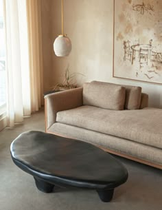 a living room with a couch, coffee table and large painting hanging on the wall