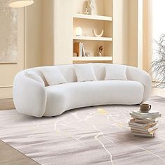 a white couch sitting on top of a rug next to a book shelf in a living room