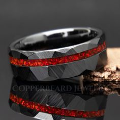 two men's wedding bands with red and black diamonds inlayed to each other