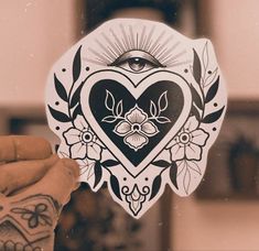 a person holding up a heart shaped sticker