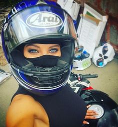 a woman wearing a helmet is posing for the camera