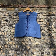 a blue vest hanging on a stone wall