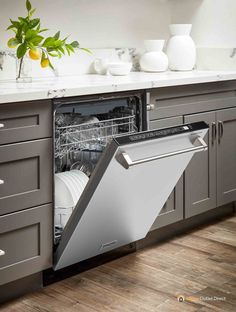 a dishwasher that is open in the middle of a kitchen with wooden floors