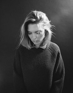 a black and white photo of a woman wearing a sweater