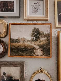 a wall with many pictures and frames on it