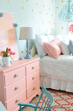 a bedroom with pink furniture and gold polka dot wallpaper