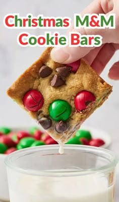 christmas m & m cookie bars being dipped with marshmallows and chocolate chips