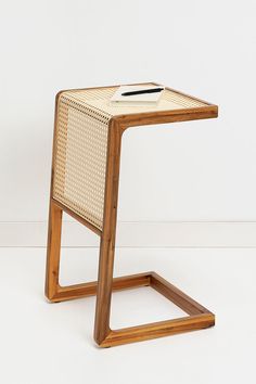 a wooden table with a book on it and a white wall in the back ground