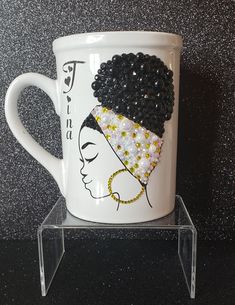 a white coffee cup with a black and gold headdress on it