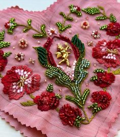 a pink heart shaped doily with red flowers on it