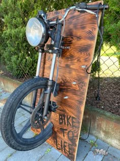 a motorcycle parked next to a wooden board