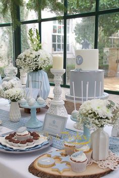 a table topped with lots of cakes and cupcakes