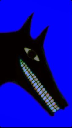 a black dog's head with white teeth and glowing eyes on a blue background