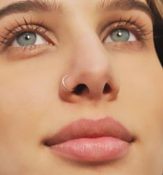 a close up of a woman's nose with a nose ring on her nose