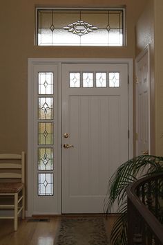 an entryway with a white door and stained glass windows