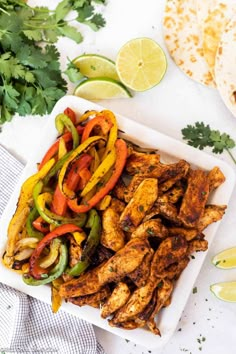 chicken fajita with peppers, onions and cilantro on a white plate