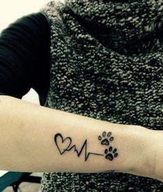 a person with a dog paw and heart tattoo on their arm