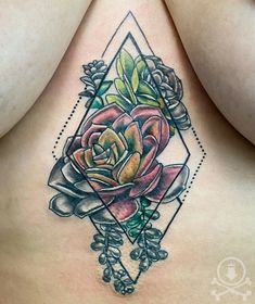 a woman's chest with a rose tattoo on it