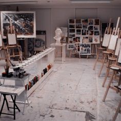 an artist's studio filled with lots of easels and paintings