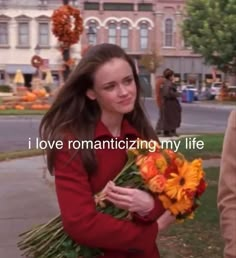 a woman is walking down the street with flowers in her hand and an inscription that reads i love romanticizing my life