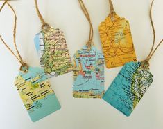 four tags are hanging from twine with maps on them, one is blue and the other is yellow