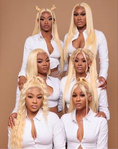 four women in white outfits posing for the camera