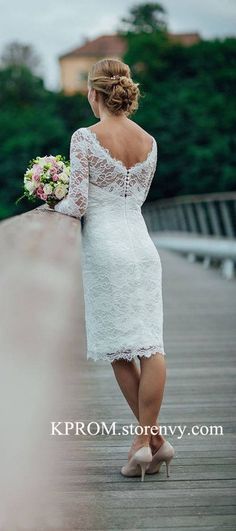 a woman in a white dress is walking on a bridge with her hand behind her back