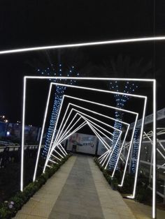 the walkway is lit up with blue lights and strips of white light on each side