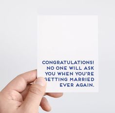 someone holding up a card that says congratulationss no one will ask you when you're getting married ever again